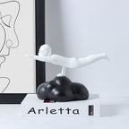 Decorative sculpture of a winged figure on a cloud with 'Arletta' branding in a minimalistic setting.