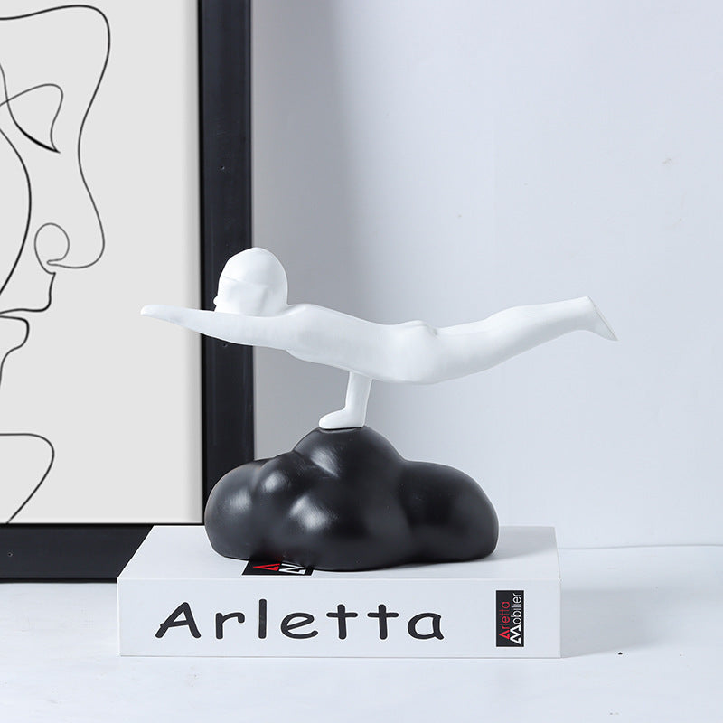 Decorative sculpture of a winged figure on a cloud with 'Arletta' branding in a minimalistic setting.
