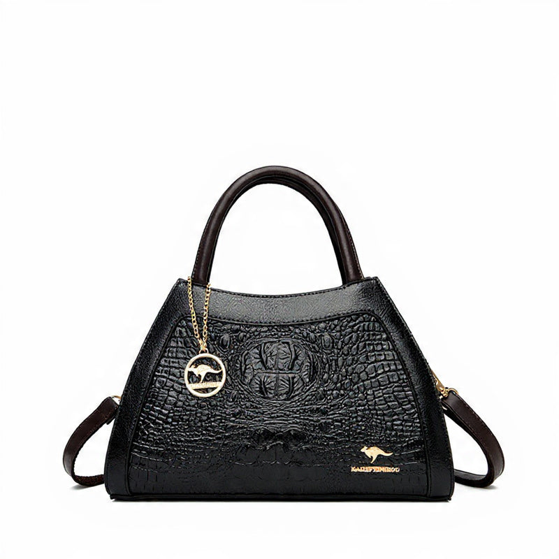 Black handbag with crocodile texture and gold chain on a white background